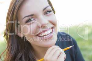 Portrait of Pretty Young Female Student with Pencil on Campus