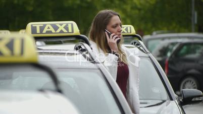 HD1080 Young woman in front of taxi with phone