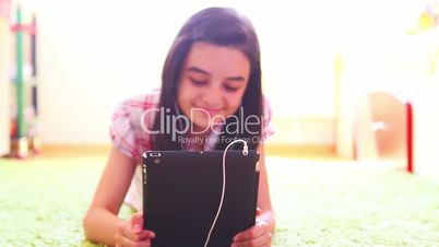 Smiling girl listening to music on digital tablet pc