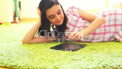 Smiling girl listening to music on digital tablet pc