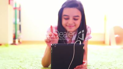 Teenage girl listening to music on digital tablet