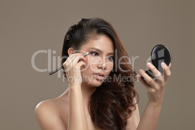 female asian applying eye shadow