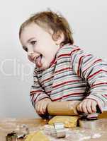 happy young child with rolling pin in grey background