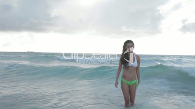 woman in a bikini walking out of the sea