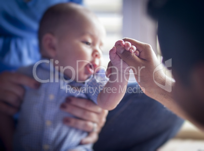 Cute Mixed Race Infant Boy Holds Father's Thumb