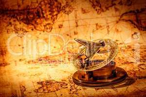 Vintage compass lies on an ancient world map.