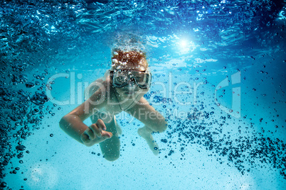 Teenager in the mask and snorkel swim underwater.