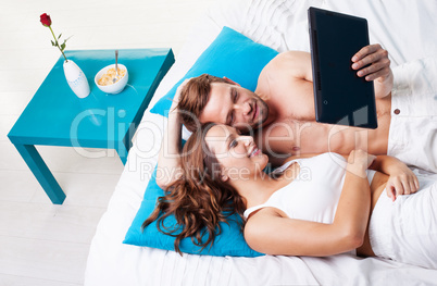 young couple reading a tablet screen