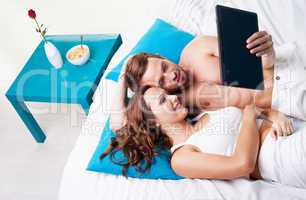 young couple reading a tablet screen