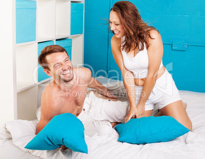 young couple having fun with pillows at home