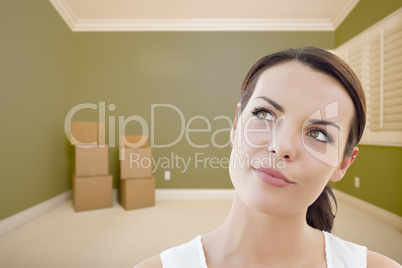 Young Woman Daydreaming in Empty Room with Boxes