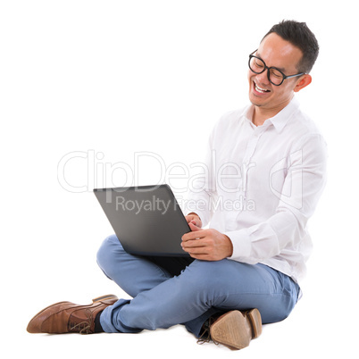 Excited Asian male using laptop