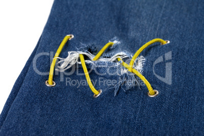 Blue jean with hole and crisscross yellow lacing