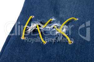 Blue jean with hole and crisscross yellow lacing