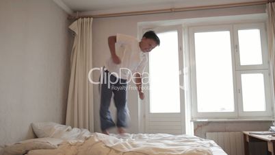 Teenager jumps on the bed