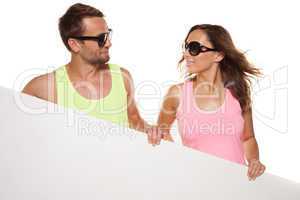 casual couple in sunglasses with a blank sign