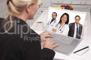 Woman In Kitchen Using Laptop, Online with Nurses or Doctors