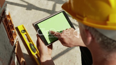 Construction worker and new house, man using digital tablet pc