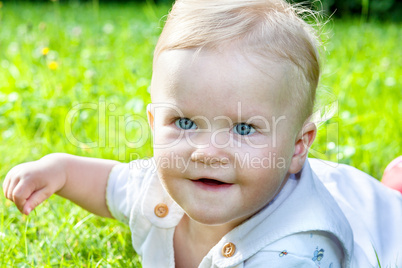 Cheerful baby girl on the summer meadow