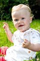 Cheerful baby girl on the summer meadow