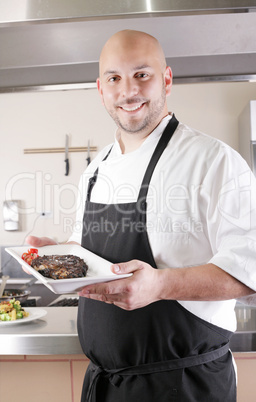 Chef presenting a juicy steak in the kitchen