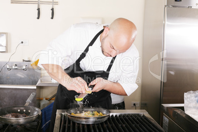 Chef putting grated parmesan to an italian pasta