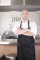 Male Chef Standing Next To Cooker In Kitchen