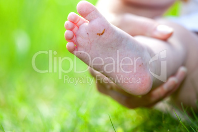 Hand holding foot of toddler