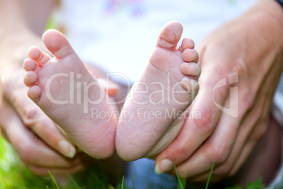 Hand holding foot of toddler