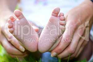 Hand holding foot of toddler