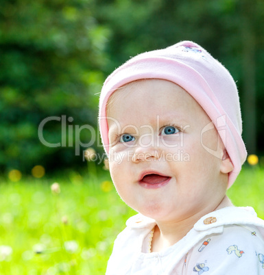 Baby with hat on the summer meadow