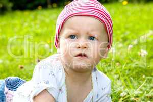 Baby with hat on the summer meadow