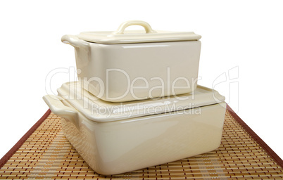 Two white ceramic pots for stove on bamboo mat