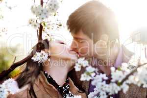 spring outdoor portrait of a young couple kissing