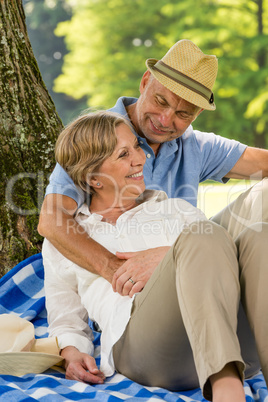 Elderly wife and husband hugging in park