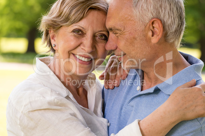 Elderly wife and husband cuddling outdoors