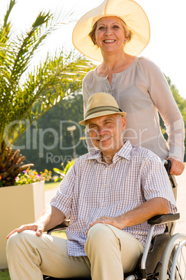Senior wife with husband in wheelchair