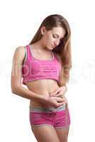 Young woman measuring her waist with a tape measure