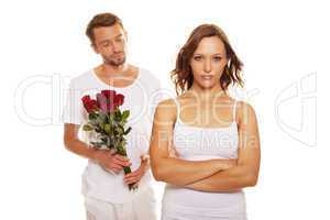 husband offering a rose to his unhappy wife