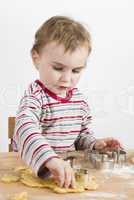 child working with dough on wooden desk