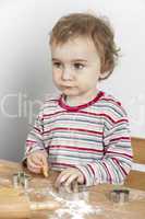 young child making cookies