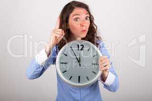 Die junge Geschäftsfrau hält eine große Uhr in den Händen