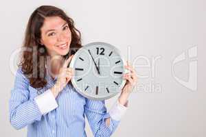 Die junge Geschäftsfrau hält eine große Uhr in den Händen