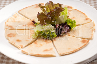 garlic pita bread pizza with salad on top