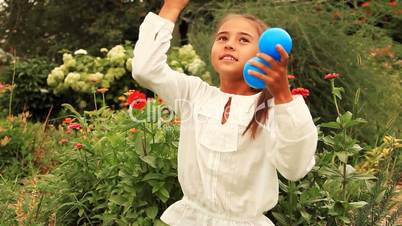 Young girl throws multicolored balls.