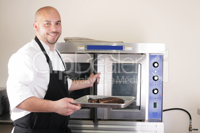 Happy chef taking his freshly baked rib-eye steak