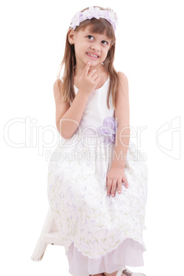 little girl wearing white dress and posing on chair on white bac