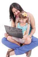 Young mother and daughter looking at laptop.  Focus in the mothe