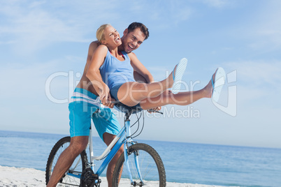 Happy man giving girlfriend a lift on his crossbar