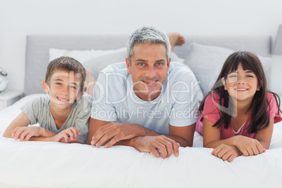 Father with his children lying on bed